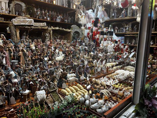 Puesto con figuras de Belén en el Paseo del Parque Puestos decorados con luces en el mercado del Paseo del Parque en Málaga durante la Navidad