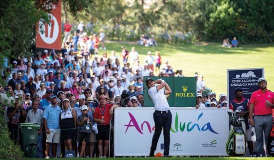 Vive el golf de clase mundial en el Estrella Damm Andalucía Masters en el Real Club Valderrama Un golfista realiza un swing en el Estrella Damm Andalucía Masters con un numeroso público de fondo en el Real Club Valderrama.