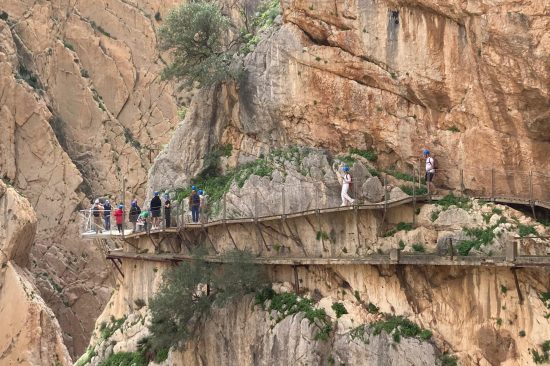 Caminito del Rey footbridge over the gorge with visitors walking along the route.