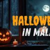 Calabaza de Halloween iluminada junto a una ventana con vela y luna llena al fondo.