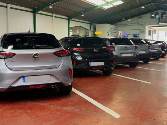 Coches de alquiler aparcados en garaje de oficina de alquiler